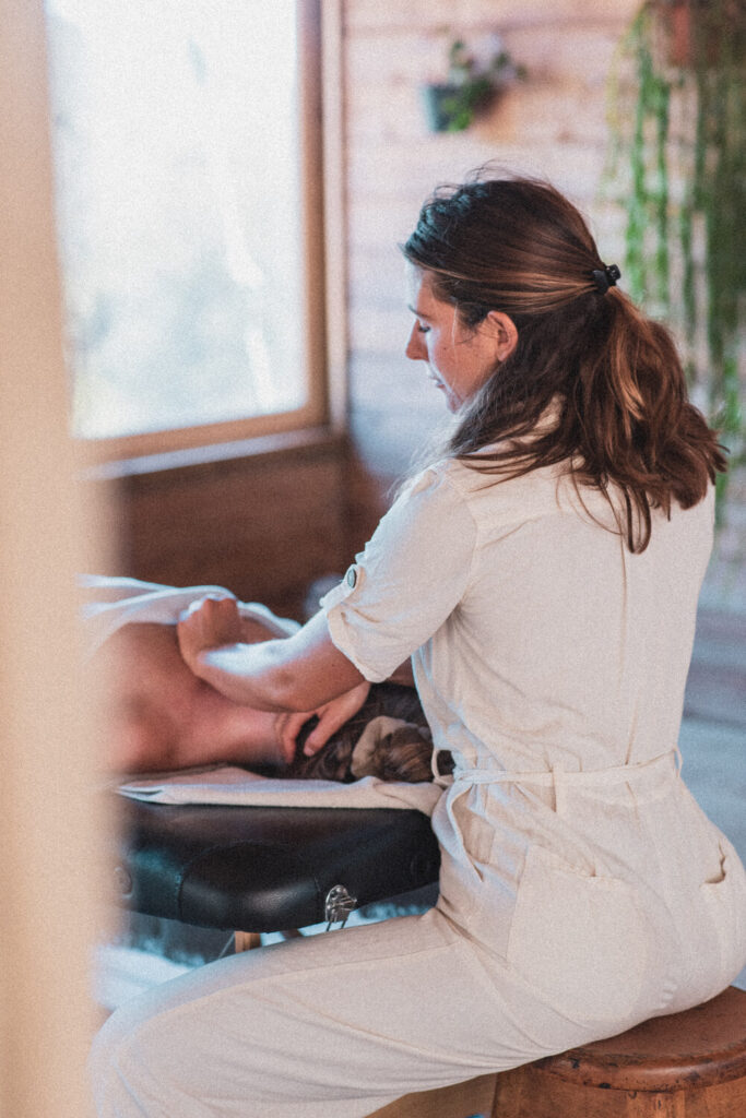 Massagista a fazer uma massagem nas costas de uma mulher