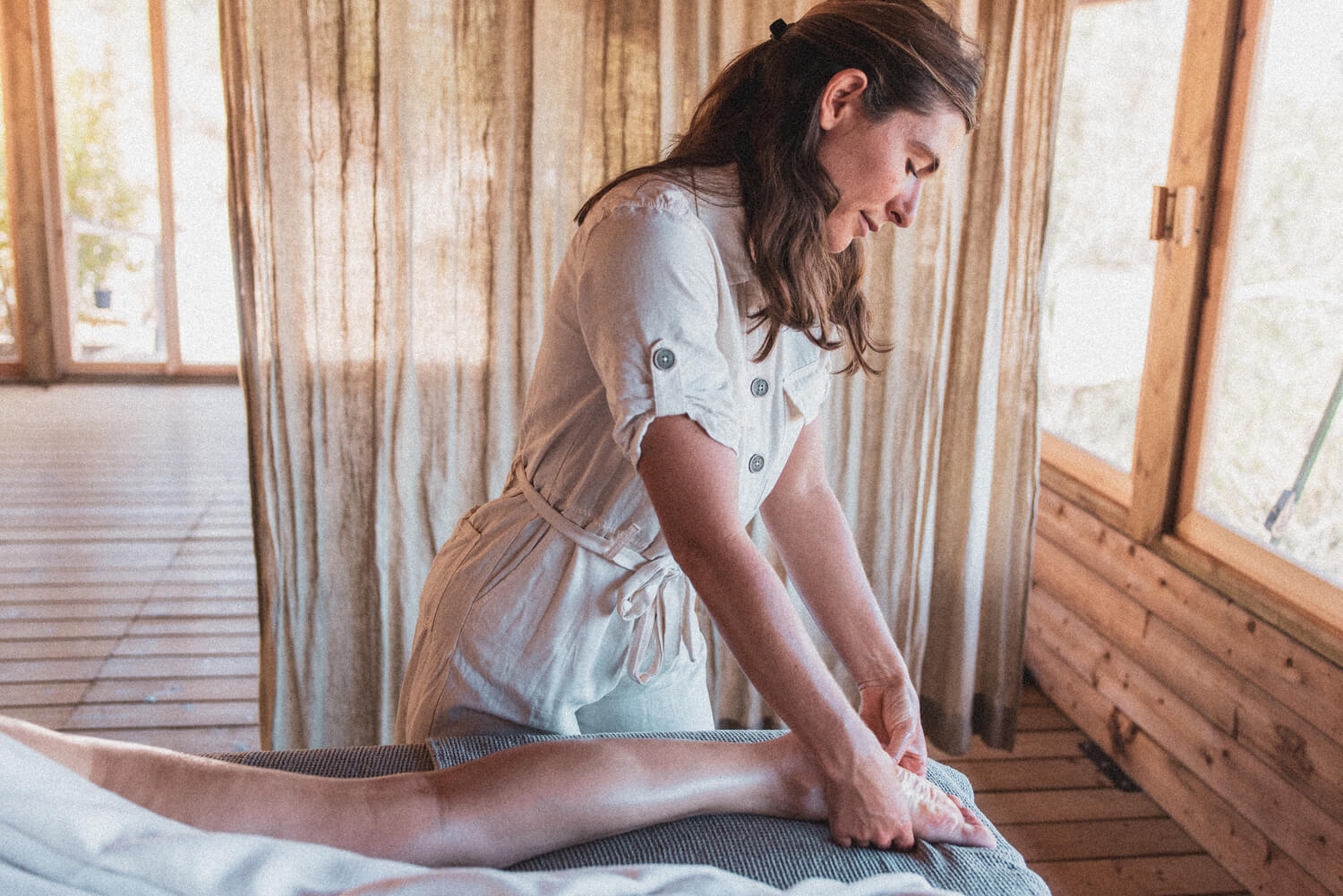 Massagista a fazer uma massagem nos pés de uma mulher