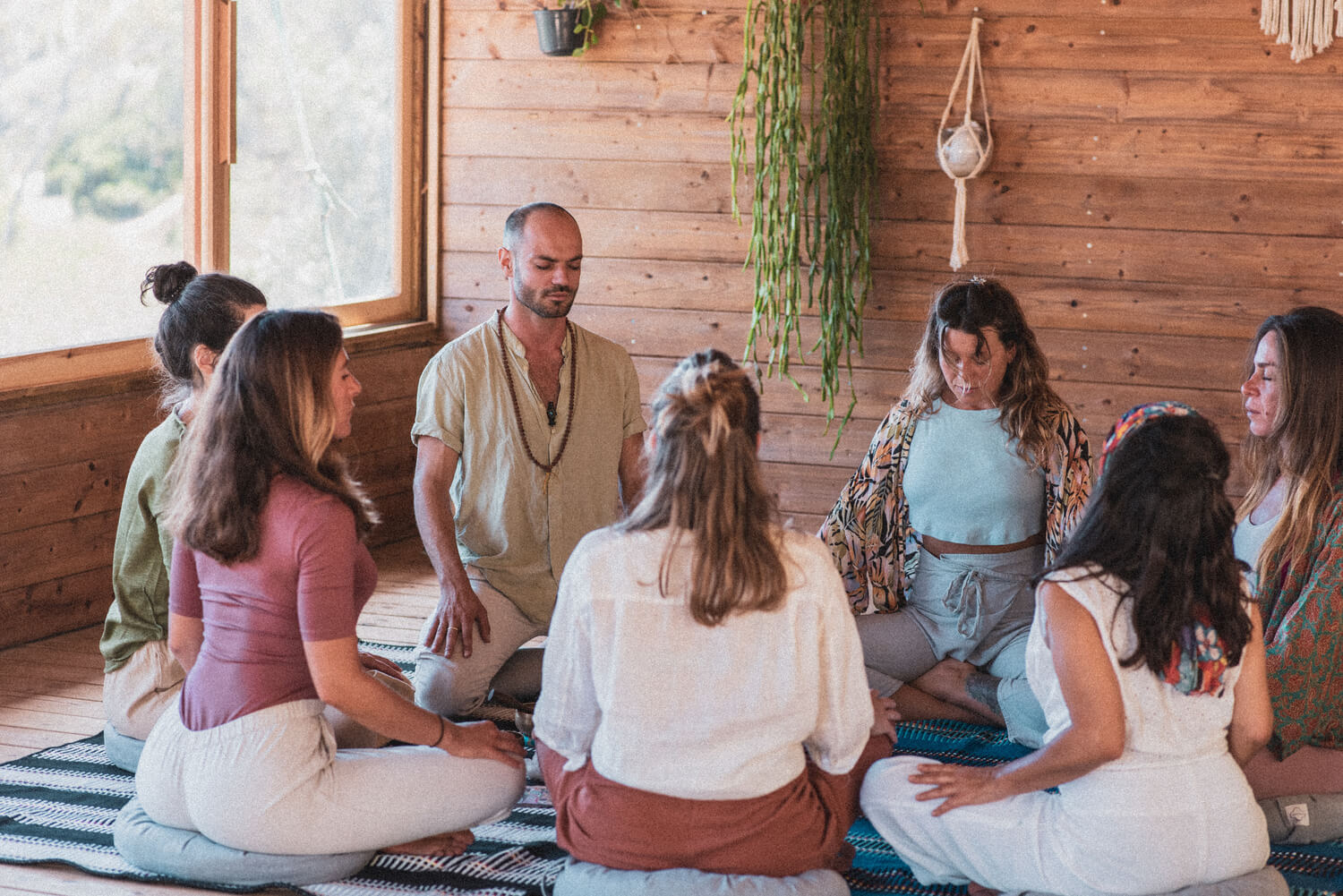 Pessoas em círculo a meditar.
