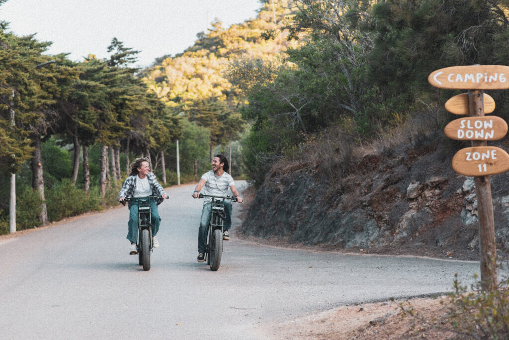Casal a sorrir enquanto anda de bicicleta pelo Salema Eco Camp