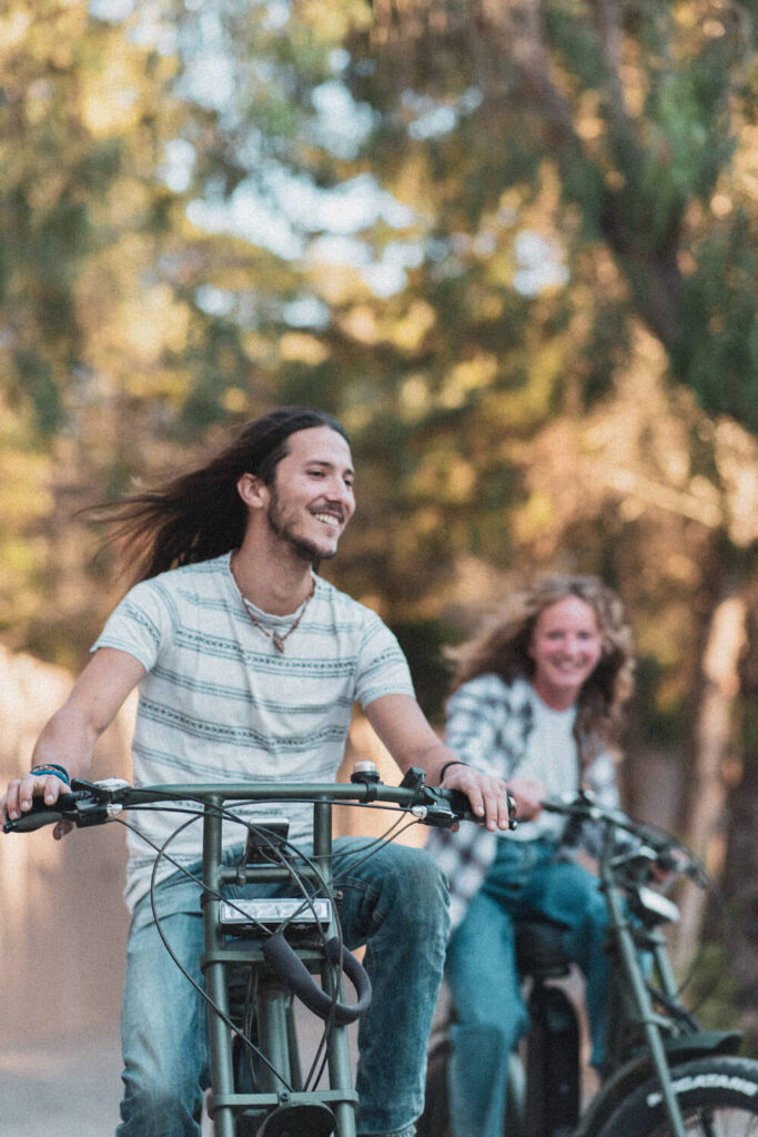 Casal a sorrir enquanto anda de bicicleta pelo Salema Eco Camp