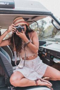 Mulher dentro de uma carrinha a apontar a c&acirc;mara para tirar uma foto."