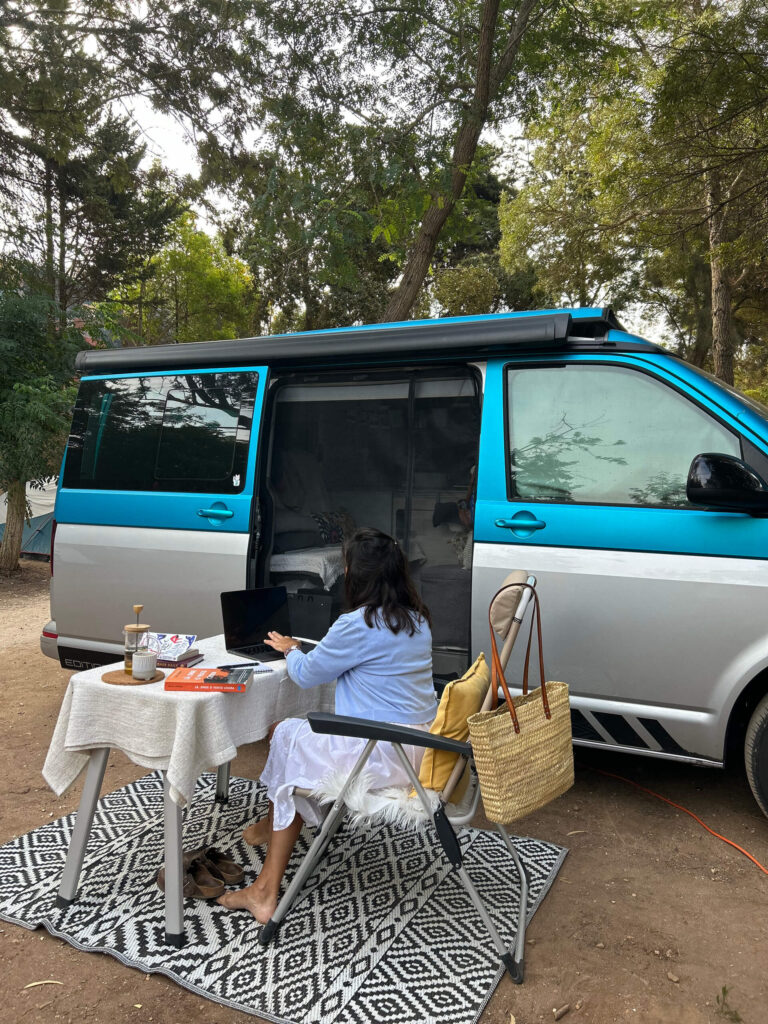 Mulher a trabalhar em frente à sua carrinha no Salema Eco Camp.