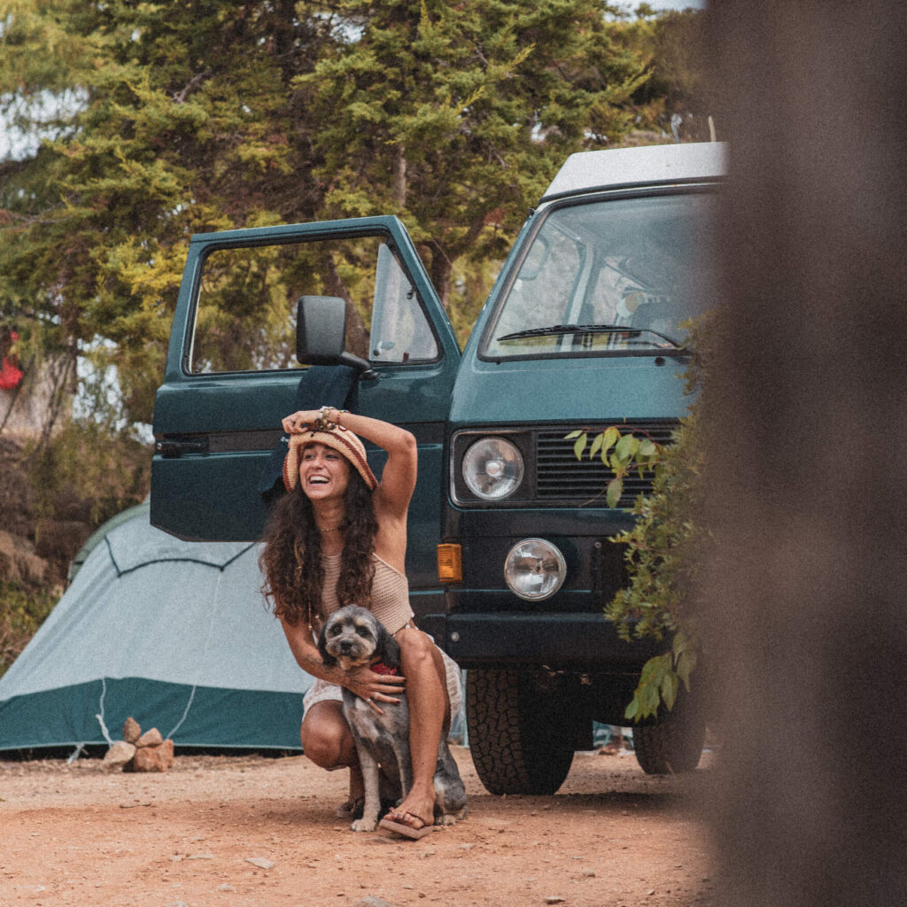 Mulher a sorrir com o seu cão no Salema Eco Camp